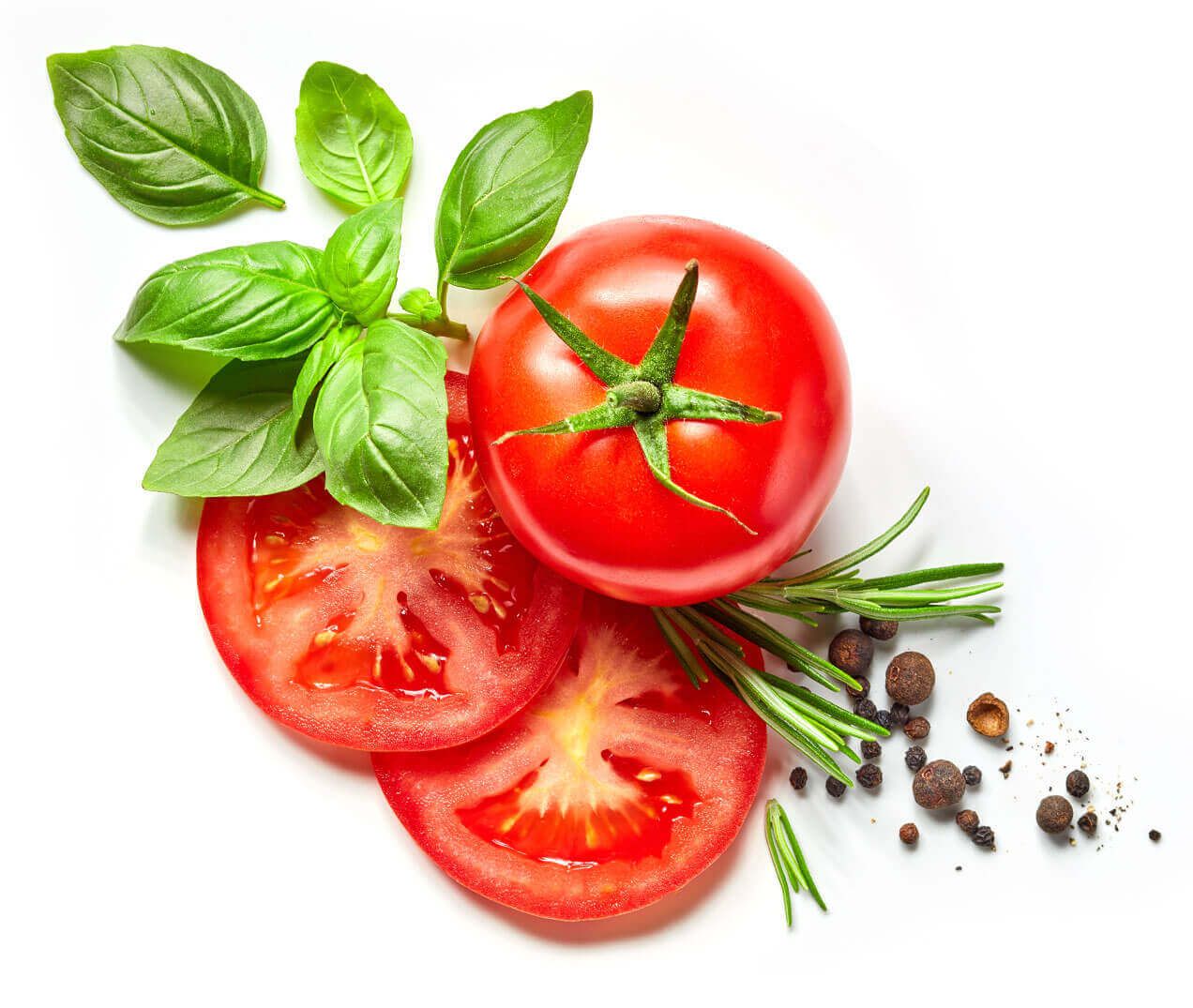 Frische rote Tomatenscheiben, begleitet von ganzen Tomaten, Basilikumblättern und Rosmarinzweigen auf weißem Hintergrund.