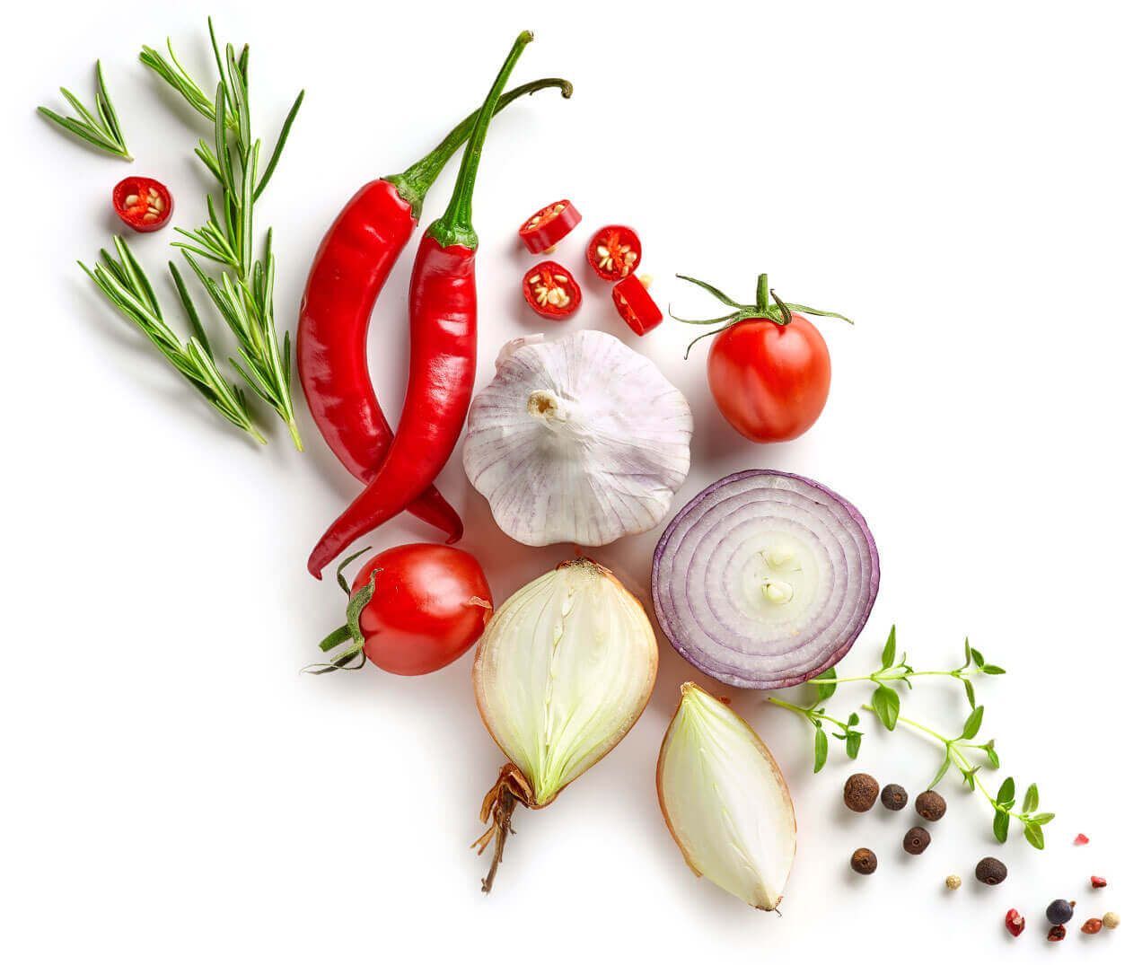 Ein lebhaftes Arrangement von frischem Gemüse, darunter rote Chilischoten, Knoblauch, Tomaten, Zwiebeln und Kräuter auf weißem Hintergrund.